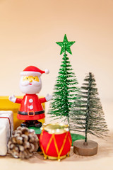 Christmas decoration concept. Santa Claus toy, gift box, pine cone and mini Christmas tree on the table. Decorative objects for Xmas and New Year holiday. Ornament for Festive season and celebration 