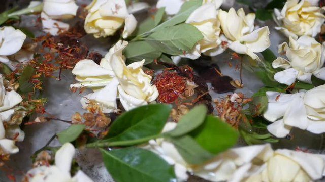 Big cup ( salung ) filled with holy turmeric water along with Cape Jasmine and sompoi, Acacia concinna, for Rod Nam Dam Hua ceremony, paying respect to the elders, during Songkran festival in Thailand