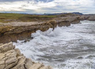 Waves breaking against cliffs