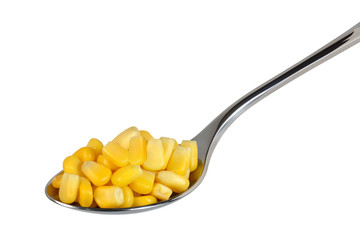 Canned corn on a spoon on a white