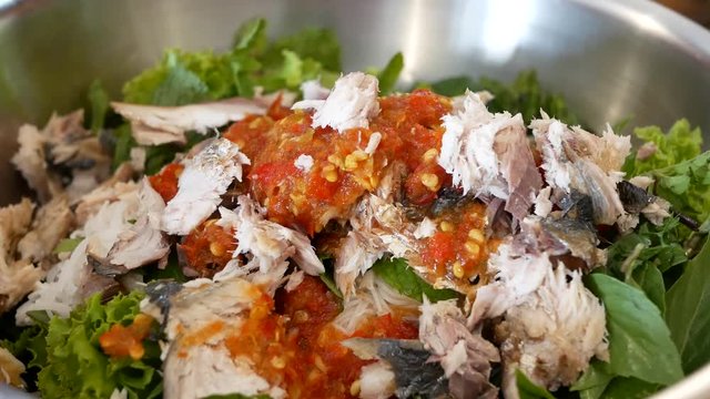 Close up of fried mackerel served with fresh vegetable with shrimp-paste sauce, Mieng Plaa Too, being prepared - delicious Thai food