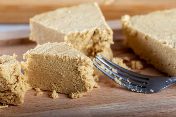 Sliced tahini halva on wooden bakcground.