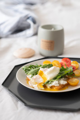 beautiful delicious breakfast, cherry tomatoes, greens and poached egg. 