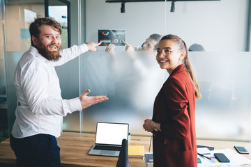 Happy office workers pointing at diagrams