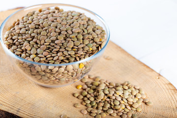Lentils in a bowl of glass on wooden board.