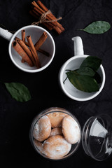 Obraz na płótnie Canvas cookies in a glass jar, cinnamon sticks and leaves of plants. Flat lay