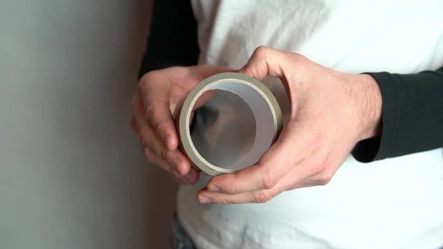 Man hands can not find edge of duct tape