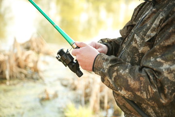hands of a fisherman hold a fishing rod