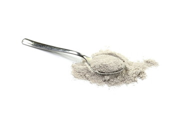 cappuccino powder in a metal spoon isolated in white background.