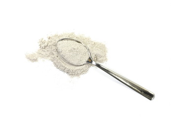 cappuccino powder in a metal spoon isolated in white background.