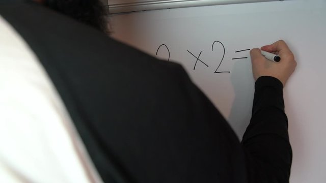 Teacher counting basic multiplication on flip chart