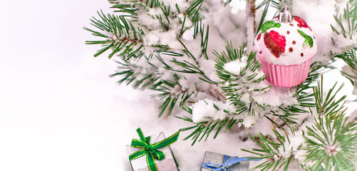 New Year's gifts in real snow on the street under a green holiday tree with a toy