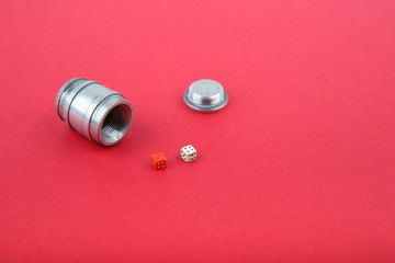 dice in a barrel on red background with copy space