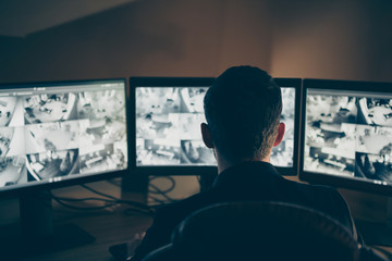 Rear back behind view of his he professional expert supervising remote panel using safety system...