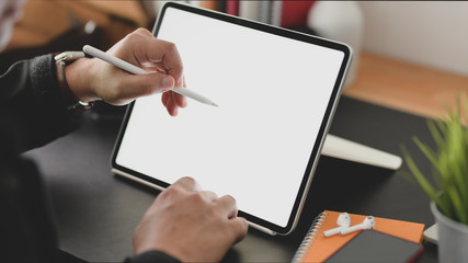 Cropped shot of businessman using blank screen tablet in modern office room