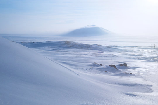 Winter arctic landscape with snow covered tundra and hills. Very cold frosty weather in April in the far north of Russia. Location place: Chukotka, Siberia, Russian Far East. Polar region.