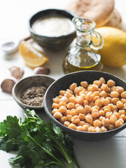 Set of ingredients for cooking homemade traditional hummus on white wood background. Copy space