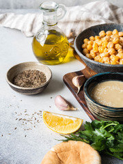 Set of ingredients for cooking homemade traditional hummus on a grey background.