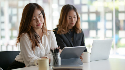 Two professional businesswomen working on the project together in modern office