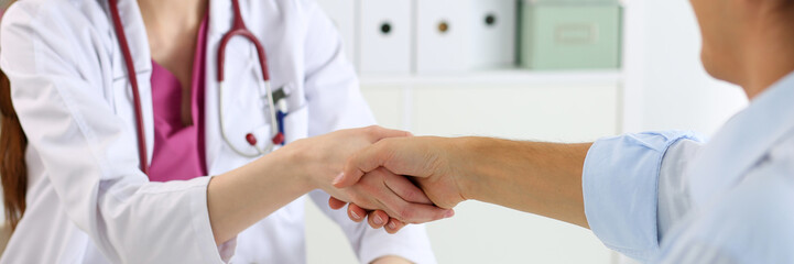 Female medicine doctor shake hand as hello with male patient