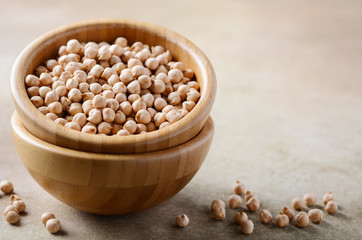 Raw organic chickpeas in a wooden bowl, healthy vegan vegetarian food ingredient.
