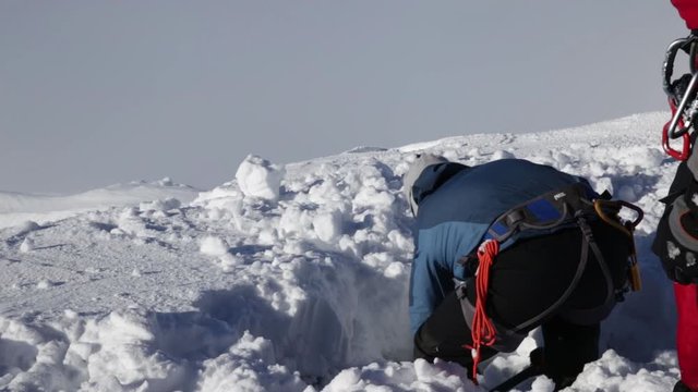 Man digging the snow with shovel for checking the avalanche dangerous in winter mountains. meteorological research of avalanche risk.