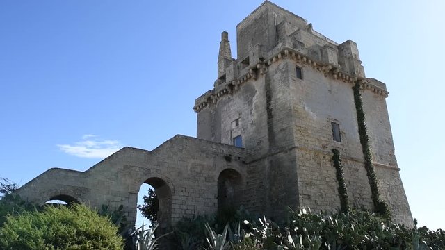 Panoramic view of Torre colimena's fortified tower. An ancient fortified tower in a summer seaside landscape of a touristic resort in Puglia, Italy. Historical monument of Torre Colimena's port