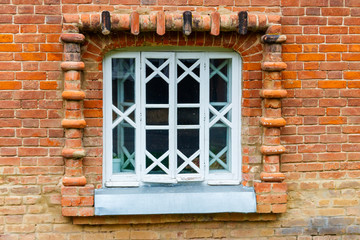 White wooden window on old red brick wall