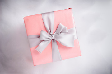 Top view of pink gift box with ribbon on white