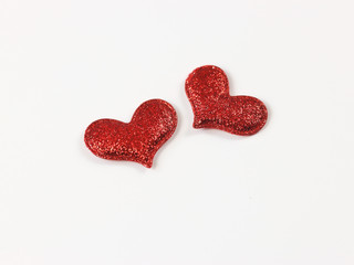 Close up of two red glitter hearts on white background