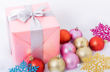 Christmas gifts and balls on snow background