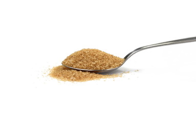 Closeup pile brown sugar in a metal spoon isolated on white background.