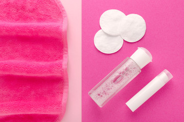 make up remove products, micellar water, face cleaning cloth and cleansing milk with cotton pads on pink background