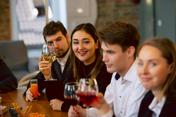 Happy co-workers celebrating while company party and corporate event. Young caucasian people in business attire cheering, laughting. Concept of office culture, teamwork, friendship, holidays, weekend.