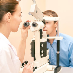 ophthalmologist doctor in exam optician laboratory with male patient. Men eye care medical...