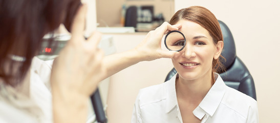 ophthalmologist doctor in exam optician laboratory with female patient. Eye care medical...