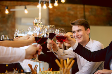 Happy co-workers celebrating while company party and corporate event. Young caucasian people in business attire cheering, laughting. Concept of office culture, teamwork, friendship, holidays, weekend.
