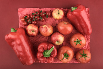 Group of red vegetables and fruits arranged forming a creative monochrome design in red. Natural ingredients for healthy eating. Lifestyle, nature and wellness concepts