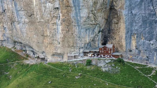 Flying around a restaurant under a cliff on mountain Ebenalp in Switzerland