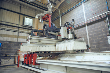 Naklejka premium Industrial automated robot machinery in an industrial workshop factory environment. Automated machinery taking jobs away from humans. Machines versus humans. mass production for corporate profits.