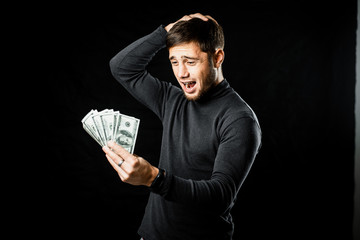 a man with a wad of money on a black background