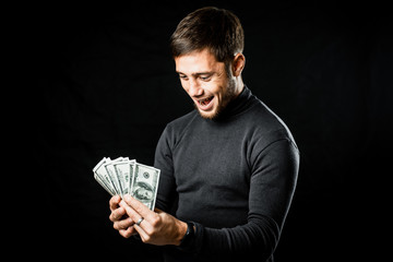 a man with a wad of money on a black background