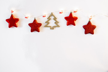 New year and Christmas card with copy space. Christmas tree garland with Christmas socks and red Christmas tree toys on it on white background