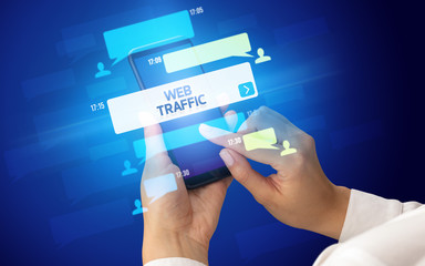 Female hand typing on smartphone with WEB TRAFFIC inscription, social networking concept