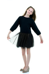 A beautiful little girl stands in the wind, her hair and clothes