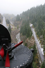 Stem locomotive and rail tracks on a rainy, snowy day
