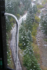 Stem locomotive and rail tracks on a rainy, snowy day