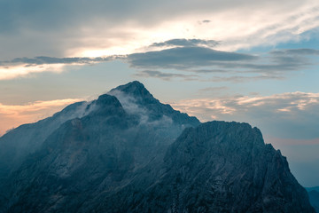 Fototapeta na wymiar Prisojnik mountain view landscape in Julian Alps in Slovenia, near Vršič pass, look from Razor mountain in cloudy weather, sunset time