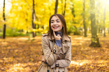 Portrait of an autumn woman with yellow leaves and smiling