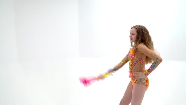 A girl gymnast performs exercises with a mace.